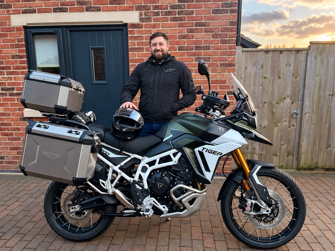 Sam standing beside his Triumph Tiger adventure motorcycle